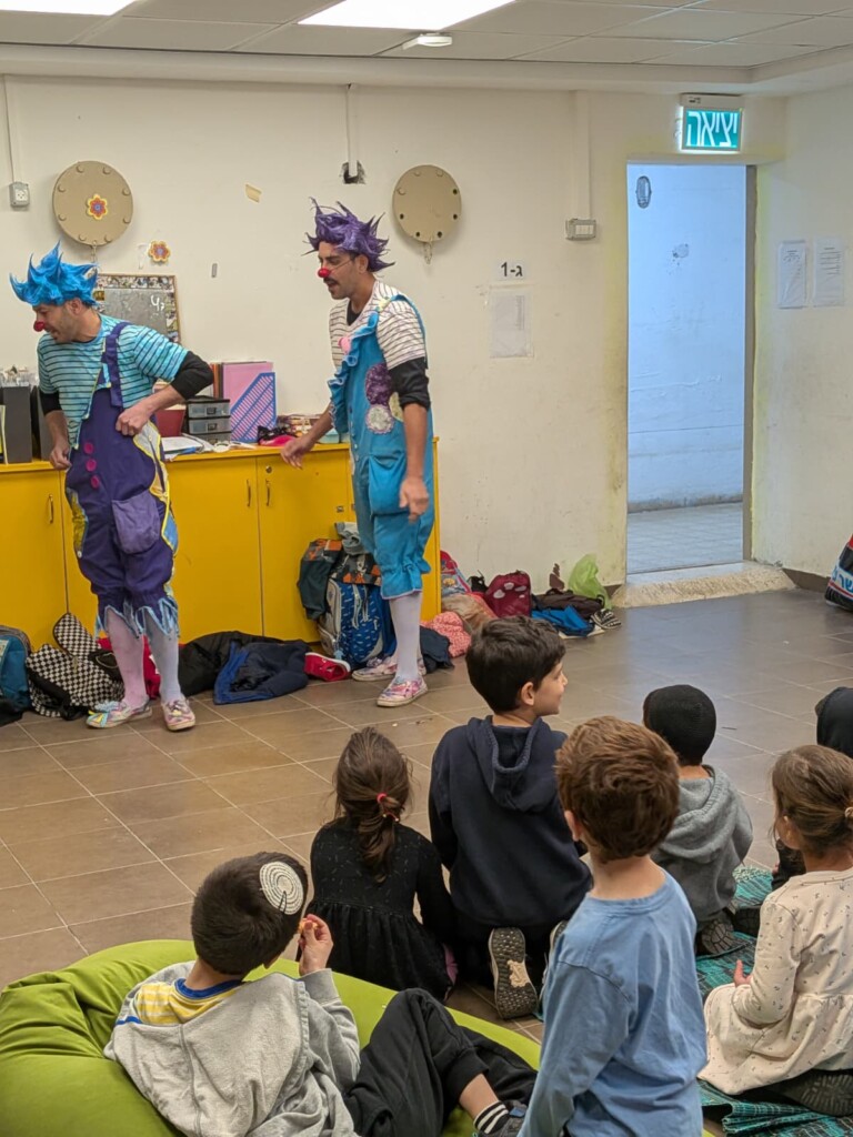 Children of emergency workers being entertained in a bomb shelter.